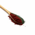 Spirulina with blackcurrant powder on wooden spoon